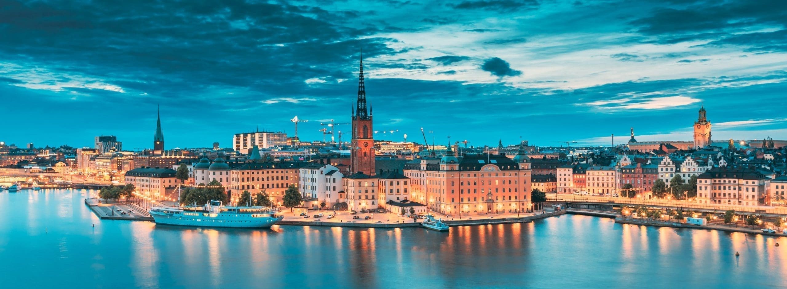 Stockholm, Sweden. Scenic View Of Stockholm Skyline At Summer Evening. Famous Popular Destination Scenic Place In Dusk Lights. Riddarholm Church In Night Lighting IBG Travel in Sweden